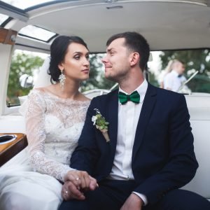 A married couple sitting in a luxurious limousine, gazing lovingly into each other's eyes.