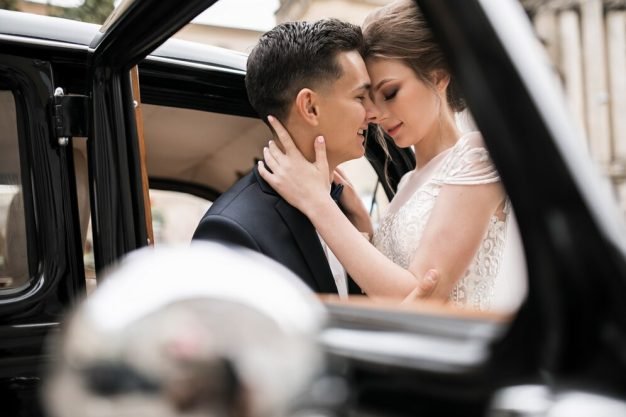 Just married couple behind open door of luxury limousine in Downtown Newark NJ
